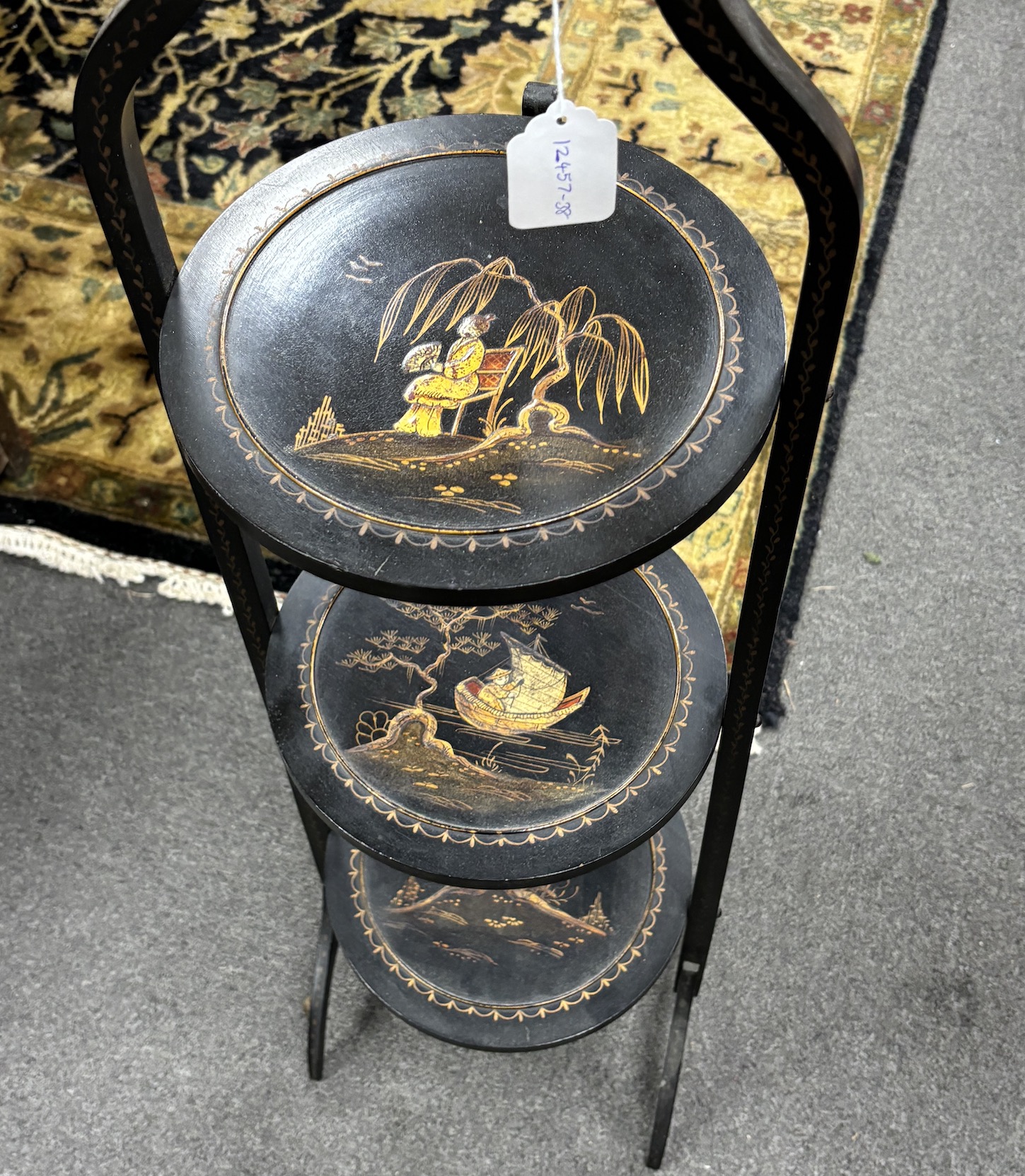 An early 20th century chinoiserie lacquered three tier folding cake stand, height 90cm